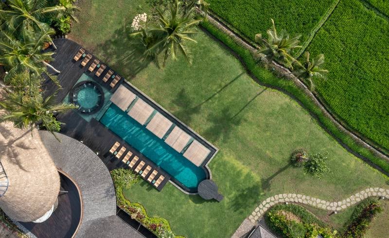 Hay una zona de piscina común con tumbonas y cabañas de madera.Foto de : Gudas Bali