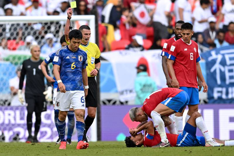 Japan's midfielder Wataru Endo receives a yellow card. AFP