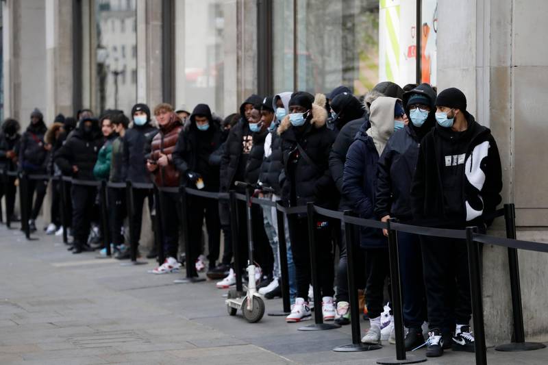 People wait outside a Nike Town shop on Oxford Street in London, on the first morning of reopening after England’s latest lockdown. AP Photo