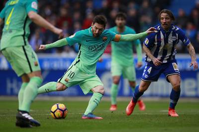 Lionel Messi, left, competes for the ball with Alexis Ruano of Alaves. Gonzalo Arroyo Moreno / Getty Images