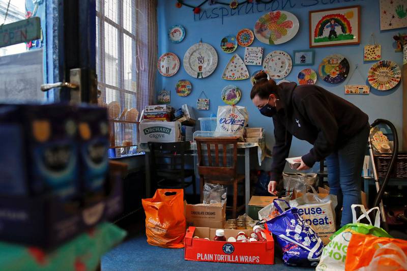 A volunteer at arts and craft shop Manic Ceramics prepares food bought from supermarkets to deliver free to families in Hertford. Reuters