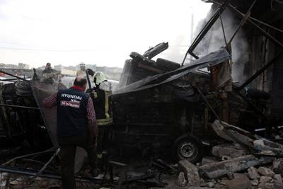 Rescuers work at the site of airstrike targeting the centre in the industrial area in the east of Idlib. EPA