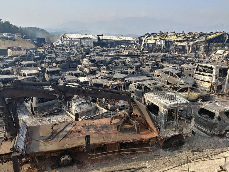Burnt vehicles fill a junkyard after being hit by a massive forest fire that started the previous day. Yonhap / EPA
