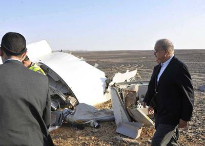 Egyptian Prime Minister Sherif Ismail, right, looks at the remains of the crashed passenger jet in Hassana, Egypt on Saturday. The prime minister said experts had confirmed that the militants could not down a plane at the 9,000 metre altitude the Airbus A321 was flying. Suliman el-Oteify / Egyptian Prime Minister’s Office via AP