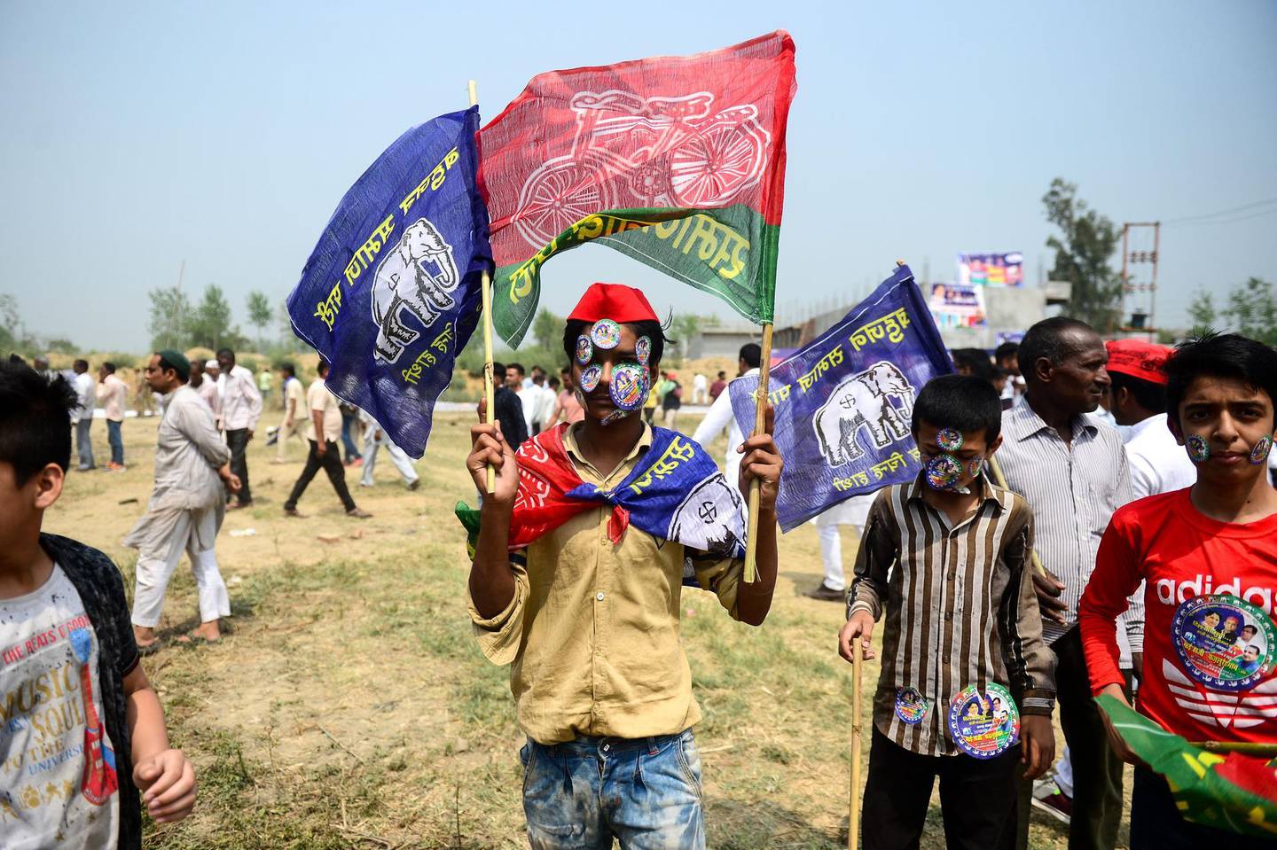 TOPSHOT - An Indian supporter of Bahujan Samaj Party (BSP), Samajwadi Party (SP) and Rashtriya Lok Dal (RLD) waves party flags at the SP-BSP-RLD alliance's first joint rally in Deoband in Uttar Pradesh state on April 7, 2019.  / AFP / SANJAY KANOJIA
