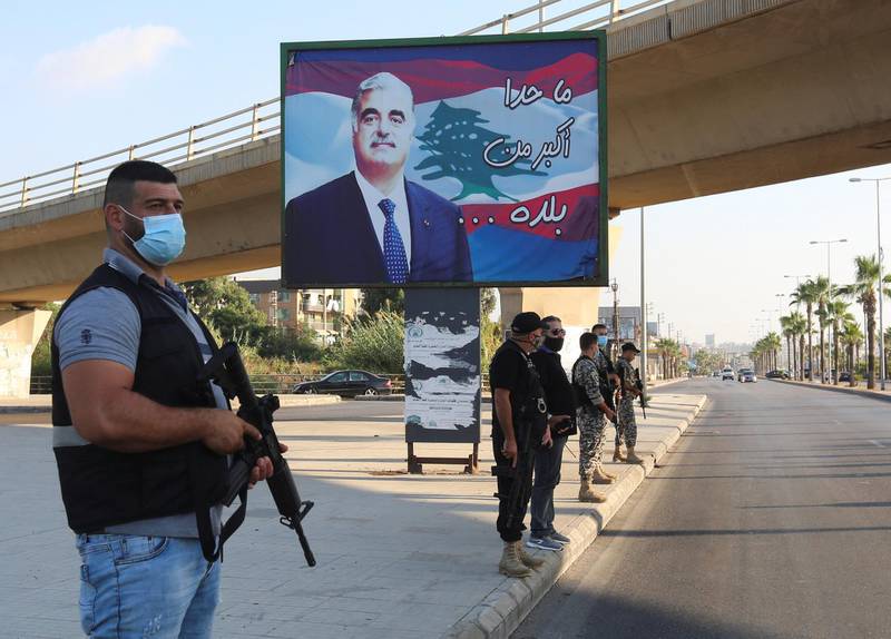 Members of security forces stand guard near a billboard depicting Lebanon's former Prime Minister Rafik Hariri, who was killed in a 2005 suicide bombing, in Sidon, southern Lebanon.  Reuters