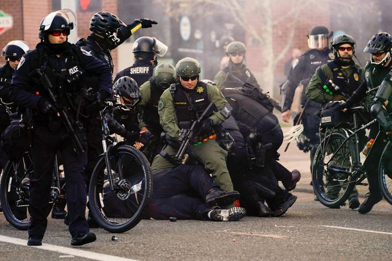 Law enforcement personnel detain an anti-fascist protester during political clashes in Olympia, Washington. AFP