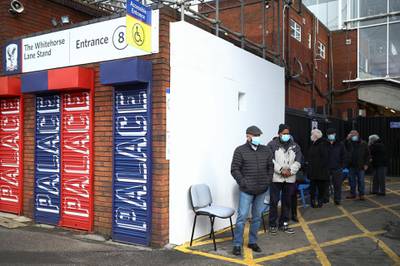 People queue as they wait to receive the vaccine at Crystal Palace Football Club vaccination centre in London. Reuters