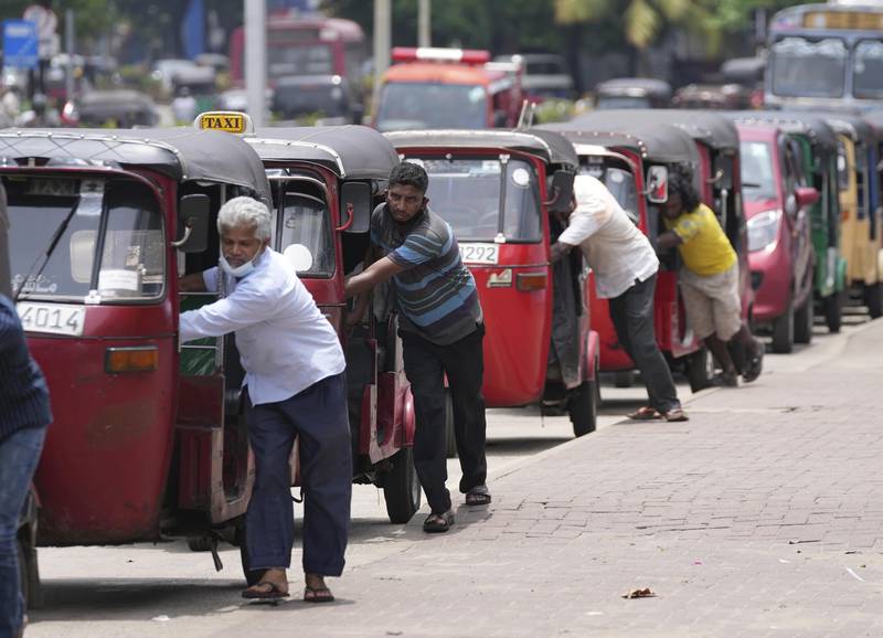 Sri Lankan auto rickshaw drivers queue up to buy petrol near a fuel station in Colombo, Sri Lanka, Wednesday, April 13, 2022.  Sri Lanka's prime minister on Wednesday offered to meet with protesters occupying the entrance to the president's office, saying he would listen to their ideas to resolve the economic, social and political challenges facing the country.  (AP Photo / Eranga Jayawardena)