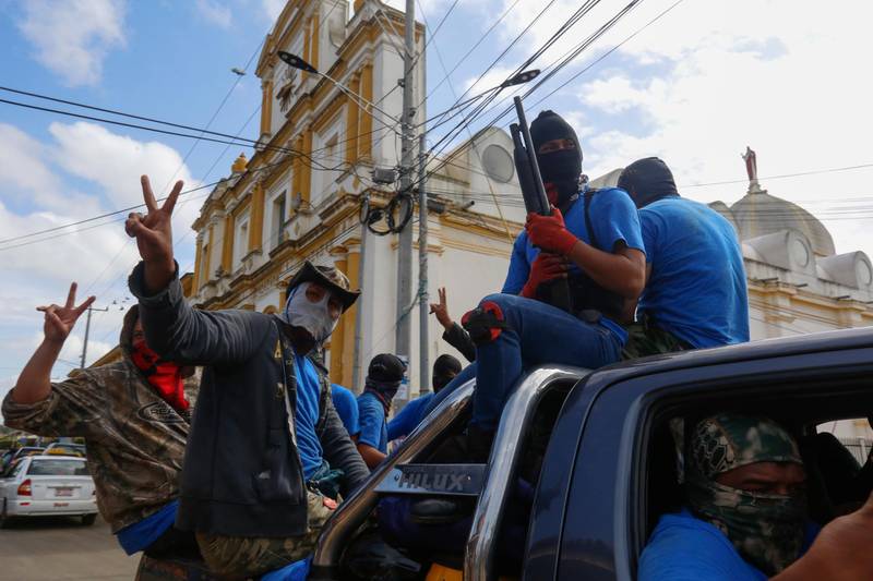 Armed pro-government militia members flash victory signs as they occupy the Monimbo neighborhood of Masaya, Nicaragua, Wednesday, July 18, 2018. On Tuesday, Nicaraguan government forces retook the symbolically important neighborhood that had become a center of resistance to Nicaraguan President Daniel Ortega's government. (AP Photo/Alfredo Zuniga)