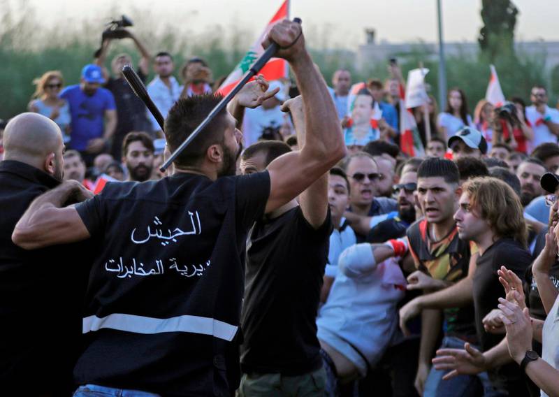Lebanese demonstrators clash with anti-riot police on the road leading to the Presidential Palace in Baabda, on the eastern outskirts of Beirut on November 13, 2019, nearly a month into an unprecedented anti-graft street movement. Street protests erupted, the night before, after President Michel Aoun defended the role of his allies, the Shiite movement Hezbollah, in Lebanon's government. Protesters responded by cutting off several major roads in and around Beirut, the northern city of Tripoli and the eastern region of Bekaa. / AFP / ANWAR AMRO
