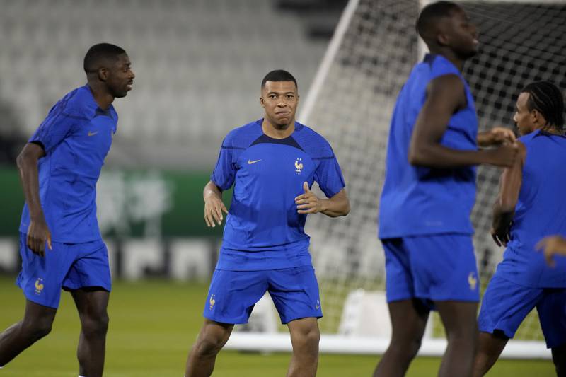 France's Kylian Mbappe, center, stretches with teammates during a training session on the eve of the group D World Cup soccer match between France and Australia, in Doha, Qatar, Monday, Nov.  21, 2022.  (AP Photo / Christophe Ena)