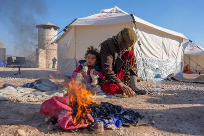 Syrians warm up by a fire outside a makeshift tent near the rebel-held town of Jindayris in Syria. AFP
