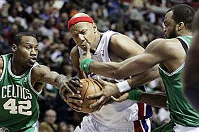 The Pistons' Charlie Villanueva, centre, gets hit in the face by the Celtics' Sheldon Williams, right.