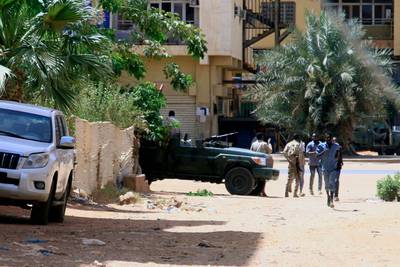 People walk past a military vehicle in Khartoum. AFP