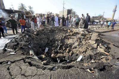 Iraqi men look at a crater left by a massive suicide car bomb attack carried out the previous day by the Islamic State group in the predominantly Shiite town of Khan Bani Saad, 20 km north of Baghdad, on July 18, 2015. The suicide attack by the IS group was one of the deadliest since it took over swathes of Iraq last year and came as the country marked Eid al-Fitr, the Muslim feast that ends the fasting month of Ramadan. AFP PHOTO / AHMAD AL-RUBAYE (Photo by AHMAD AL-RUBAYE / AFP)