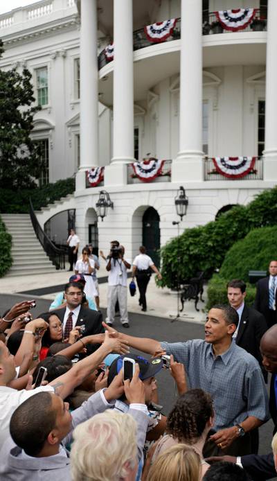 In this July 4, 2009 photo, President Barack Obama shakes hands with members of the United States armed services and their guests while hosting a Fourth of July party on the South Lawn of the White House in Washington. AP Photo