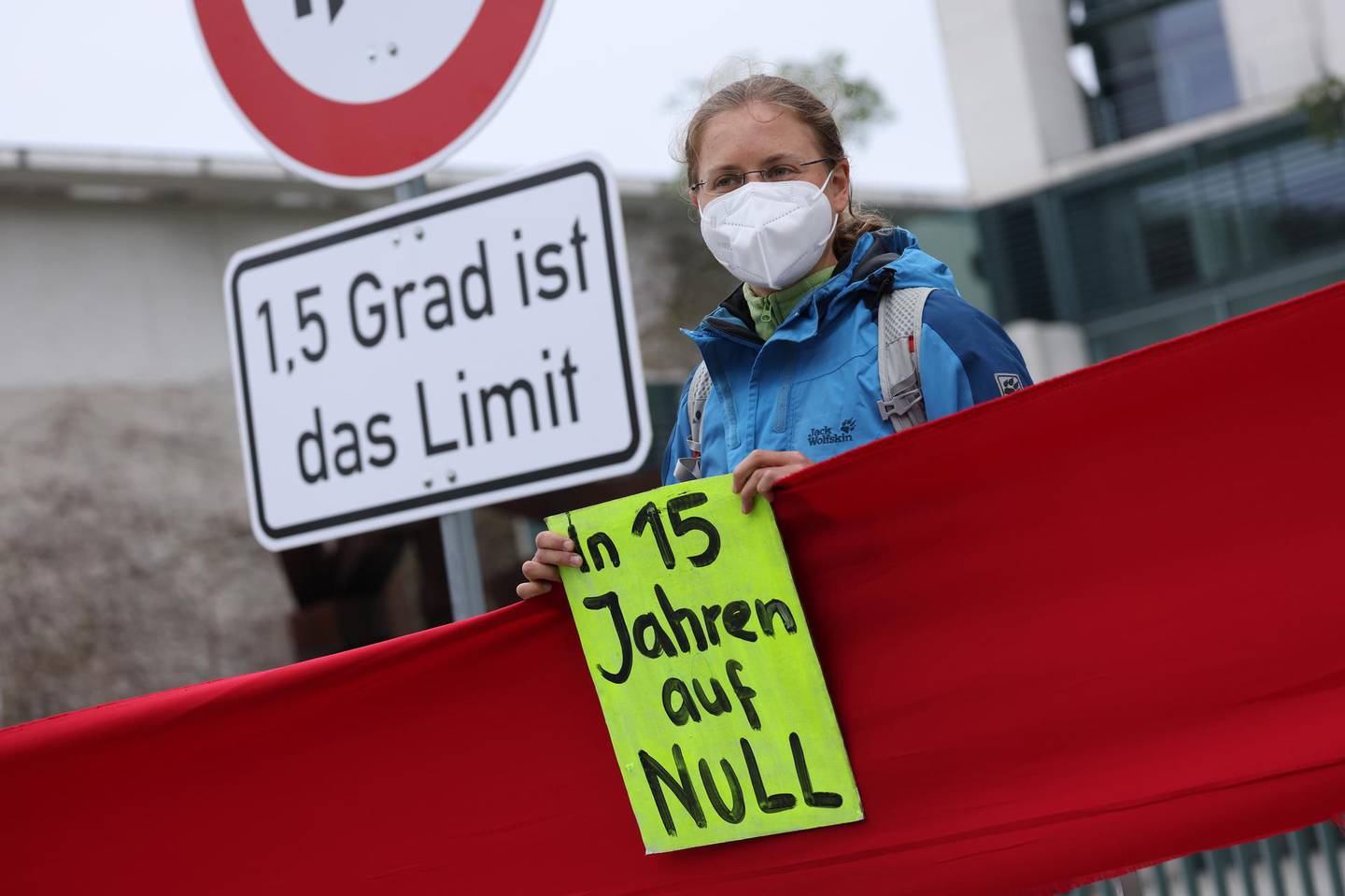 BERLIN, GERMANY - MAY 12: A supporter of the Fridays for Future climate movement holds a sign that reads: "In 15 years to zero" outside the Chancellery where earlier in the day the government cabinet met to agree on amendments to Germany's climate protection law on May 12, 2021 in Berlin, Germany. Germany's Federal Constitutional Court recently ruled that the current law is insufficient in protecting future generations from the consequences of climate change, giving climate activists, including the nine young plaintiffs who brought the suit, a big victory. However many activists are saying the new government commitment of climate neutrality by 2045 is not enough and are demanding the same goal but for 2035. (Photo by Sean Gallup/Getty Images)