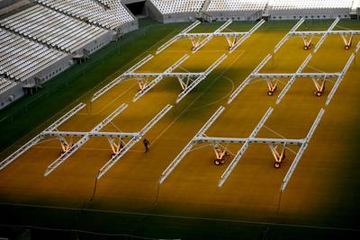 A ground staff works on the pitch of the Lusail Stadium. AFP