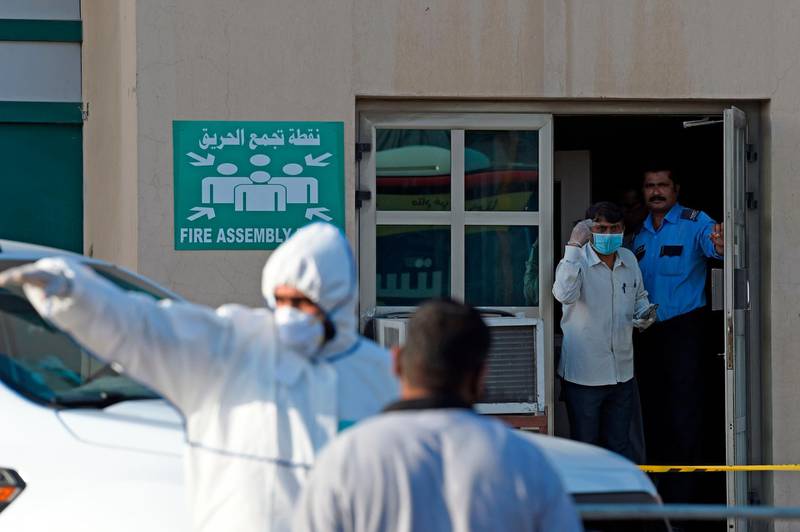 Bahraini policemen seal off a building housing foreign workers in the Salmabad industrial area as a precautionary measure after a resident tested positive for coronavirus (COVID-19), on the outskirts of the capital Manama.   AFP