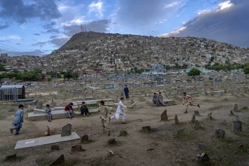 Afghan boys play cricket at a cemetery in Kabul, Afghanistan.  Cemeteries in the capital are incorporated casually into Afghans' lives.  They provide open spaces where children play and adults hang out, smoking, talking and joking, because there are few public parks. AP Photo