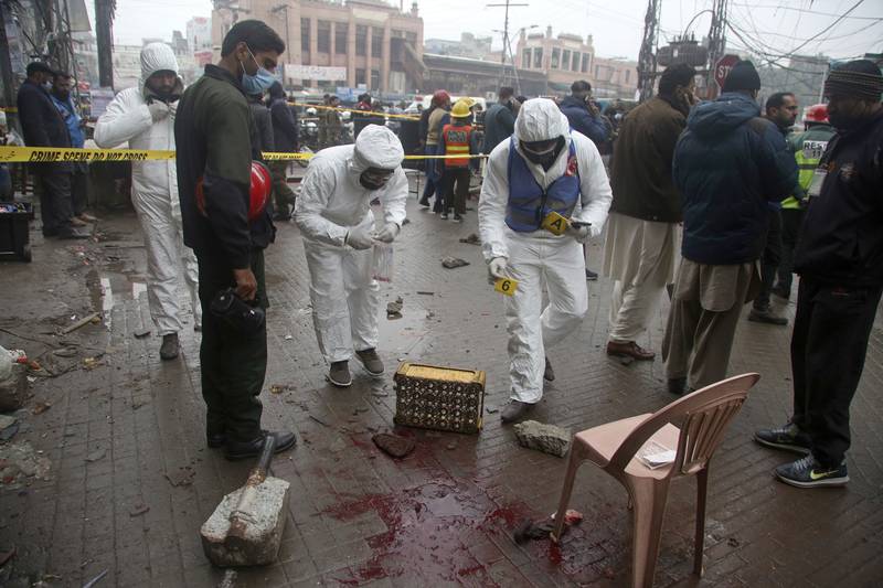 Investigators gather evidence at the site of the explosion in Lahore, Pakistan. AP