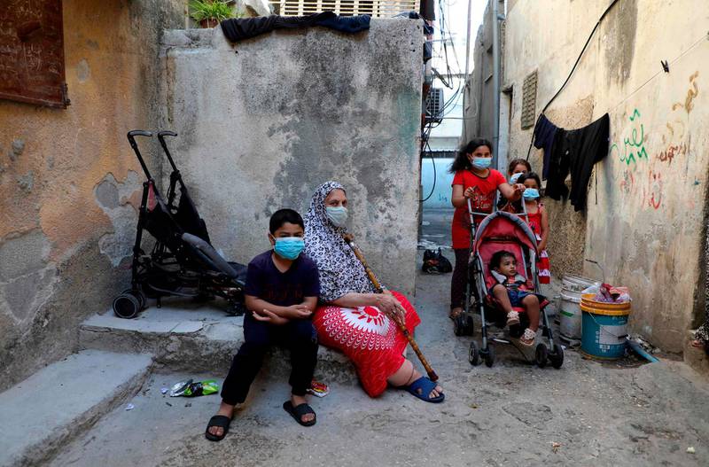 Mask-clad residents of the Askar Palestinian refugee camp, east of the occupied West Bank city of Nablus, gather in an alley. AFP