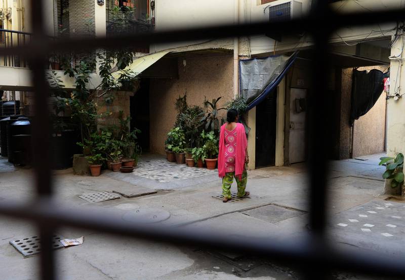 An Indian pedestrian walks past a flat in an apartment block were a domestic servant was allegedly tortured at Vasant Kunj in New Delhi on October 1, 2013. A teenage girl working as a maid in India's capital was recovering in hospital after being rescued from a home where campaigners said she was slashed with knives and mauled by dogs. AFP PHOTO/ SAJJAD HUSSAIN (Photo by SAJJAD HUSSAIN / AFP)