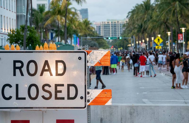 A large crowd gathers on a walkway near the beach, during spring break in Miami Beach, Florida. The city of Miami Beach is imposing a curfew for its entertainment district. Officials will also close the three causeways heading into the beach. The measures are being put into place as an effort to control large crowds that have gathered during spring break. EPA