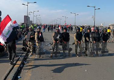 Iraqi anti-riot police stand guard while anti-government protesters gather for a demonstration in Baghdad on Friday. AP