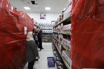 People shop at a mall next to covered French products in protest against French cartoons of the Prophet Mohammed in Amman, Jordan. Reuters