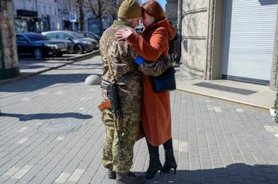 Igor, a 40 year-old Ukranian soldier, embraces his wife in front of his military basement in the centre of Odesa.  AFP