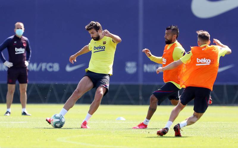 Gerard Pique plays the ball under pressure from Arturo Vidal during a training session at Ciutat Esportiva Joan Gamper. Getty Images