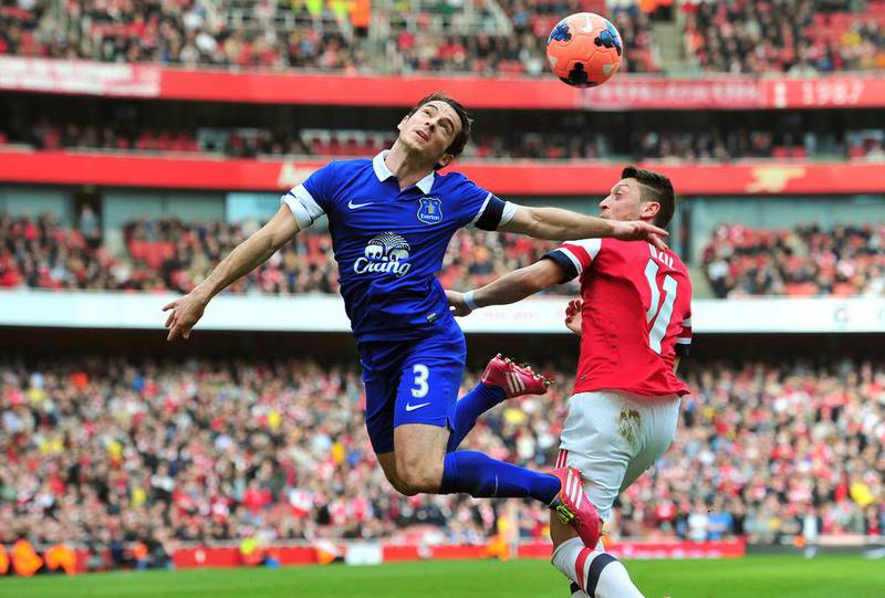Arsenal’s German midfielder Mesut Ozil, right, vies with Everton’s English defender Leighton Baines during the English FA Cup quarter final football match between Arsenal and Everton at the Emirates Stadium in London on March 8, 2014. Glyn Kirk / AFP