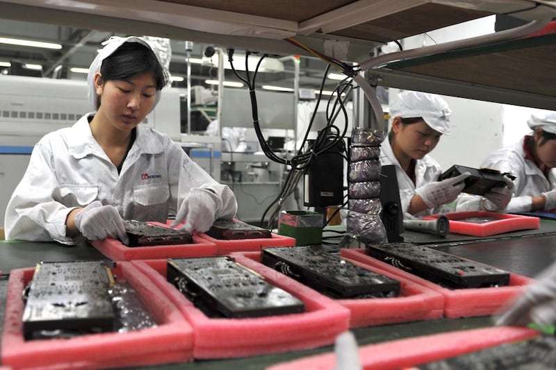 Workers inspect motherboards on a factory line at the Foxconn plant in Shenzen. The Taiwanese company, which manufactures Apple’s iPhone in China, revealed plans to create 10 to 12 factories and up to 1 million jobs in India by 2020. Voishmel / AFP