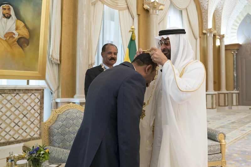 ABU DHABI, UNITED ARAB EMIRATES - July 24, 2018: HH Sheikh Mohamed bin Zayed Al Nahyan Crown Prince of Abu Dhabi Deputy Supreme Commander of the UAE Armed Forces (R), presents a Zayed Medal to HE Dr Abiy Ahmed, Prime Minister of Ethiopia (L), during a reception at the Presidential Palace. Seen with HE Isaias Afwerki, President of Eritrea (back C)
( Mohamed Al Hammadi / Crown Prince Court - Abu Dhabi )
---