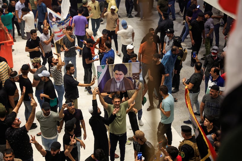 A person holds a portrait of Mr Al Sadr. Reuters