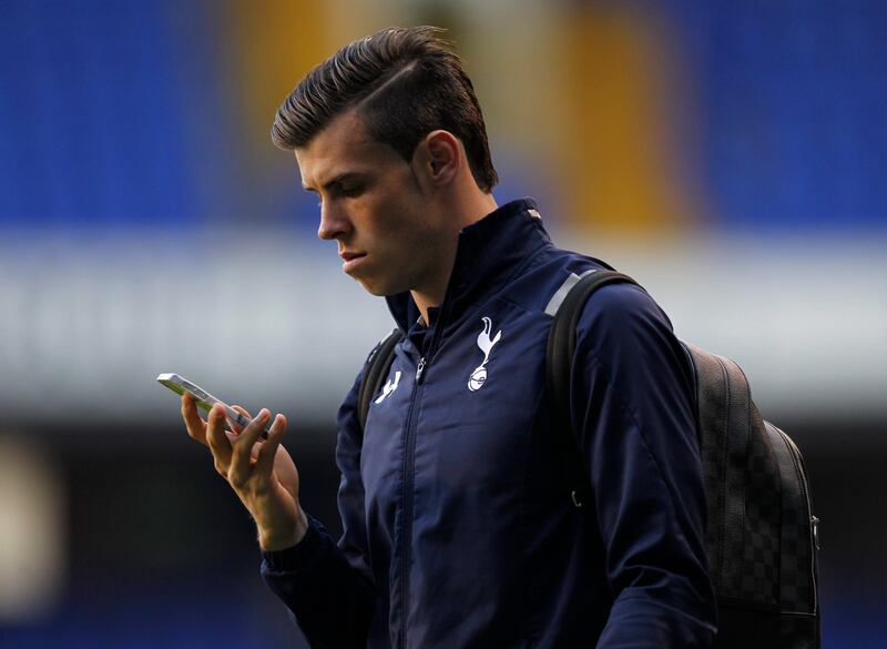 Tottenham Hotspur's Welsh midfielder Gareth Bale looks at his phone as he leaves the ground after the English Premier League football match between Tottenham Hotspur and Sunderland at White Hart Lane in north London on May 19, 2013. Tottenham missed out on Champions League qualification to Arsenal despite Gareth Bale's 90th-minute winning goal.  AFP PHOTO / IAN KINGTON

RESTRICTED TO EDITORIAL USE. No use with unauthorized audio, video, data, fixture lists, club/league logos or “live” services. Online in-match use limited to 45 images, no video emulation. No use in betting, games or single club/league/player publications
 *** Local Caption ***  153117-01-08.jpg