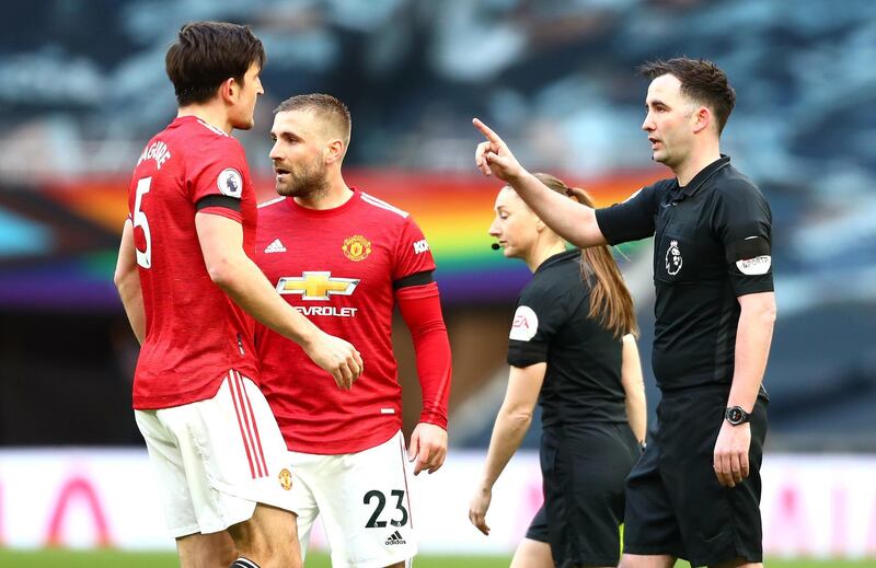Manchester United's Harry Maguire and Luke Shaw confront referee Chris Kavanagh at half-time. PA