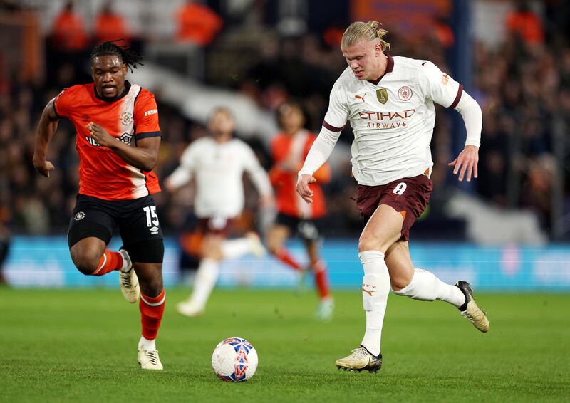 Erling Haaland of Manchester City runs with the ball under pressure from Teden Mengi of Luton Town. City ran out 6-2 winners at Kenilworth Road to advance to the quarter-finals of the FA Cup. Getty