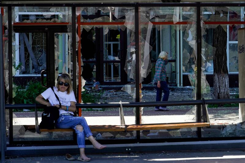 A woman sits at a destroyed bus station in the city of Mariupol. AFP