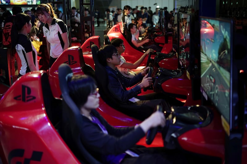 Visitors try out a car driving game at the Tokyo Game Show in Chiba. Eugene Hoshiko / AP Photo