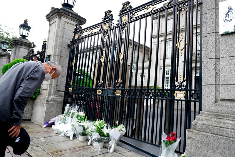 A man bows at the gate of the British Embassy in Tokyo. AP