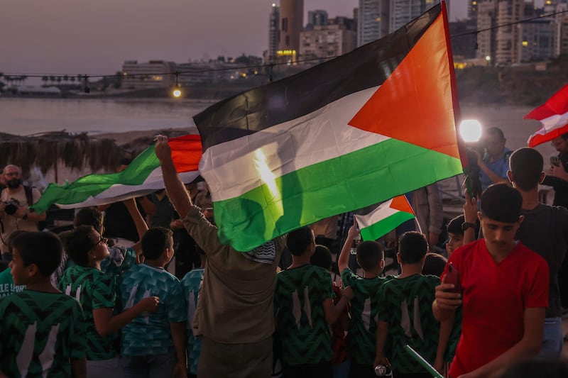 Lebanese lift Palestinian flags during a solidarity vigil in Beirut. AFP
