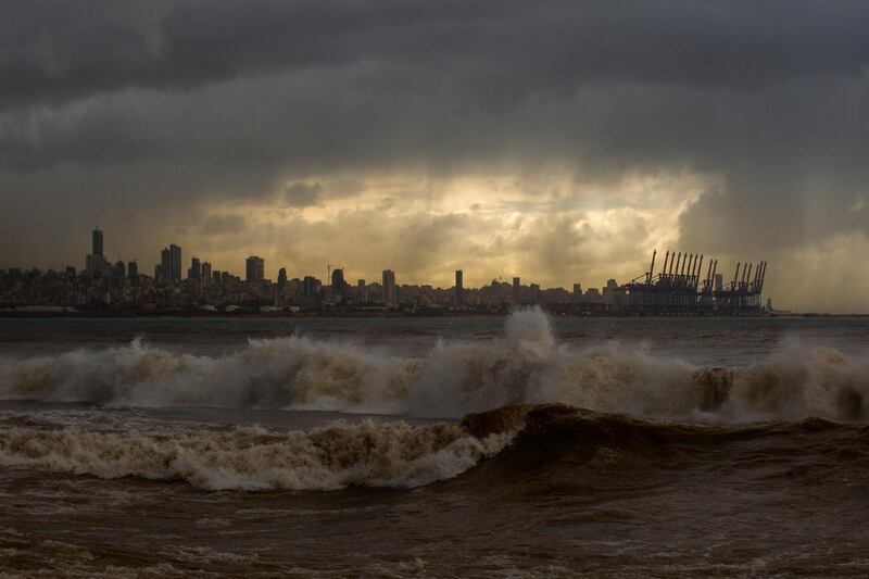 Heavy clouds hover over Beirut as waves crash on the seawall of the corniche, in Dbayeh, Lebanon, Wednesday, Feb. 17, 2021. Storm Joyce hit late Tuesday with gale force winds registering up to 100 km/h (62 miles/h). (AP Photo/Hassan Ammar)