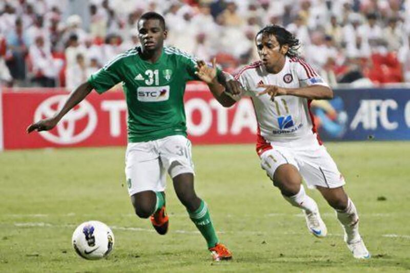 ABU DHABI, UNITED ARAB EMIRATES - May 22, 2012 - Al Ahli's Mansour Al Harbi (L) keeps Al Jazira's Hassan Alrahem Æ from the ball during second half football action of their Champions League match at Mohammed Bin Zayed Stadium in Abu Dhabi City, Abu Dhabi, May 22, 2012. (Photo by Jeff Topping/The National)