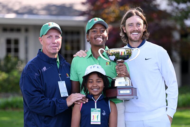 Maya Gaudin poses with the trophy with her father Steve Gaudin, her sister Willa Gaudin, and Tommy Fleetwood after winning the Drive, Chip and Putt Championship at Augusta National Golf Club. Getty