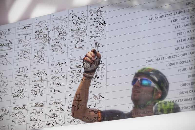 A rider signs the entry board on Thursday on the first day of the Abu Dhabi Tour. Mona Al Marzooqi / The National