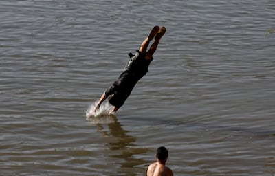 A man dives into the Tigris to escape the summer heat in Baghdad. Reuters