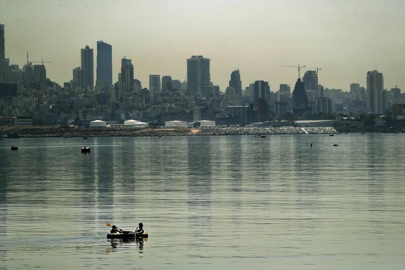 Two men row an inflatable boat off the coast of the Lebanese capital Beirut during a heatwave. AFP